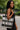 Woman holding a black and white patterned tote bag outdoors.