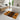 Patterned bath mat on a bathroom floor with a bathtub and sink in the background.