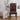 A high-back dining chair with a vibrant African tribal geometric pattern in red, orange, yellow, black, and white, styled next to a white side table and lamp in a minimalist room.