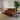 Brown leather sofa with a patterned Kuba throw blanket in a living room setting.