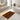 Bathroom with a patterned orange and black rug on the floor.