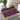 Colorful geometric patterned placemat on a glass table with a teapot and cup in the background.