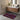 Bathroom with a patterned rug on the floor, wooden vanity, and sink.