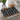 Geometric patterned placemat on a glass table with a teapot and cup in the background.