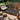 Outdoor patio with a patterned rug, furniture, and decorative elements.