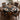Dining table set with a black and orange geometric patterned tablecloth and chairs.