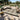 Outdoor patio with a patterned rug, furniture, and plants on a stone patio.