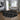 Round black and white patterned rug in a living room with a sofa and decor.