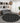 Round black rug with white patterns in a living room setting