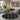 Living room with a black and white patterned rug, gray sofa, and decorative wall art.