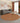 Living room with a round patterned rug, gray sofa, and decorative elements.