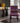 A modern dining chair with a vibrant geometric tribal pattern in black, red, purple, and white, set in a contemporary living room environment.