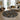 Round geometric patterned rug in a living room with a couch and decor.