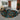Geometric patterned rug in a living room setting with a gray sofa and decorative elements.