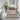 Bathroom with a patterned rug, plant, and sink area.