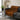 Orange and black patterned blanket draped over a gray sofa in a modern living room.