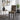 A modern accent chair with a bold geometric tribal pattern in black, mustard yellow, and white, styled in a contemporary living room next to a gold-framed side table and lamp.