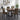 A dining table set in a modern dining room, featuring a rectangular wood table with black metal legs and four upholstered chairs with a bold geometric pattern in black, mustard yellow, and brown.