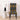A high-back dining chair with a vibrant Kente-style woven fabric cover in black, yellow, and blue, styled in a modern room next to a white side table with a black lamp.