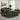 Living room with a round green and black patterned rug, gray sofa, and green chair.