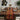 Dining table set with a patterned table runner, chairs, and decor in a modern room.
