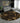 Living room with a gray sectional sofa and a round black rug with gold patterns.