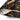 Close-up of a square throw pillow with a black, orange, and white geometric pattern, showing the zipper and off-white fabric lining.
