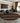 Living room with a round patterned rug, gray sofa, and decorative elements.