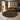 Round patterned rug in a living room with a brown sofa and abstract art on the wall.