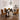 A 5-piece dining set featuring a rectangular glass-top table and four matching upholstered chairs with a bold yellow, black, and brown geometric pattern, styled in a modern dining room.
