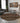 Living room with a round geometric patterned rug, sofa, coffee table, and wall art.