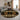 Round black and gold patterned rug in a living room setting with a sofa and decor.