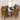 A modern dining room set featuring a rectangular glass-top table with a metallic base and six high-back chairs upholstered in a bold yellow, black, and brown geometric patterned fabric.