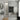 Modern bathroom interior with gray tiles, a mirror, sink, and decorative wall art.