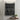 Black and white patterned towel hanging on a tiled wall with a small plant and soap dish below.