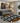 Modern living room with a round geometric patterned rug, gray sofa, and decorative elements.